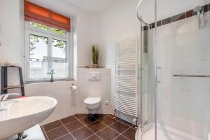 a white bathroom with a sink and a toilet at Ferienhof Schönberg in Lindow +40 photos