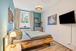 a bedroom with a bed and a flat screen tv at Ferienhof Schönberg in Lindow