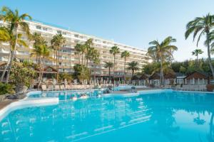 a large hotel with palm trees and a large swimming pool at Bull Costa Canaria & Spa - Only Adults in San Agustin