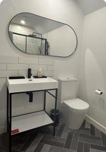 a bathroom with a sink and a toilet and a mirror at Kelsingra Self Catering in Lerwick/Tingwall Airport