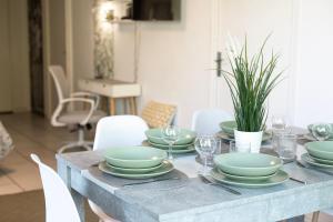 a dining room table with green dishes on it at Appartement Cosy Case 6 pers parking proche Disney et Paris in Champs-sur-Marne