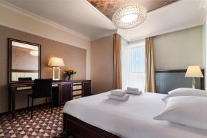 a hotel room with a bed and a desk and a mirror at Aparthotel Vanilla in Krakow +88 photos
