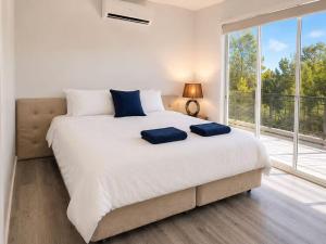 a bedroom with a large bed and a large window at 22 Pimpama Home in Pimpama