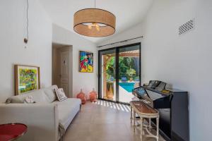 a living room with a couch and a piano at Villa avec piscine chauffée, proche Saint-Tropez et plages in Gassin