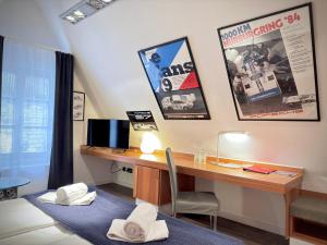 a room with a desk with a computer and posters on the wall at Hotel Reinhardts in Bietigheim-Bissingen