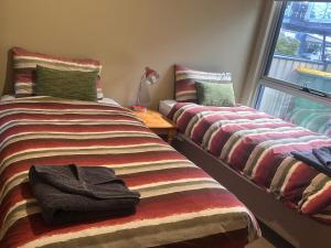 two beds sitting next to a window in a room at Unit 4 The village light house in Metung