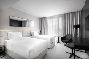 a hotel room with two beds and a desk at Clarion Congress Hotel Brno in Brno