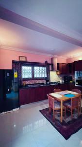 a kitchen with a wooden table and a dining room at AB Home Suites in Asofa