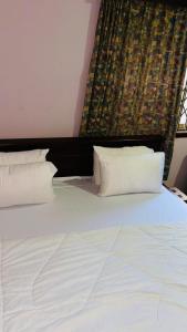 a large white bed with pillows in a room at AB Home Suites in Asofa