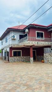 a red and white house with a large driveway at AB Home Suites in Asofa