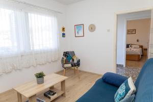 a living room with a blue couch and a table at Sea View apartment 50 m from St Rok Beach in Pučišća