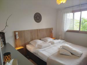 a bedroom with two beds with white sheets and a window at Home 33 in Saint-Rémy-lès-Chevreuse