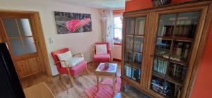 a living room with a book shelf and a table at Fewo2-Fliegenpilz in Bad Suderode