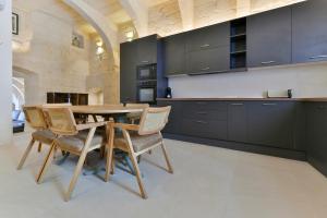 a kitchen with a wooden table and chairs at Xewkija Ta' L-Ghagin in Xewkija