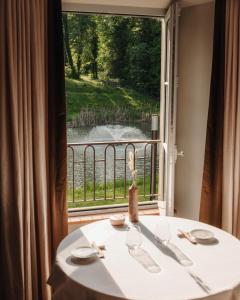 a table in front of a window with a view at Domaine de Dolomieu Hotel & Spa - BW Premier Collection in Dolomieux