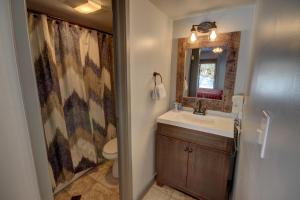 a bathroom with a sink and a toilet and a mirror at Wild Irishman 1059 by SummitCove Lodging in Colorado in Keystone