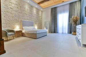 a bedroom with a bed and a stone wall at Xewkija Ta' L-Ghagin in Xewkija +28 photos