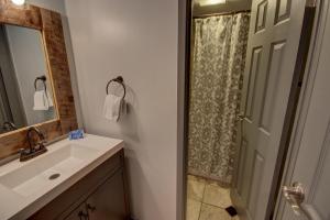 a bathroom with a sink and a mirror and a shower at Wild Irishman 1059 by SummitCove Lodging in Colorado in Keystone