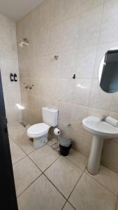 a bathroom with a toilet and a sink at Golden Silver UNIQUE in Curvelo