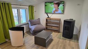 a living room with a flat screen tv on the wall at Relax House in Dommitzsch