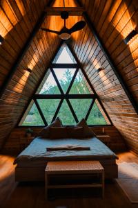 a bed in a room with a large window at Cabana A-frame D&J in Mada +36 photos