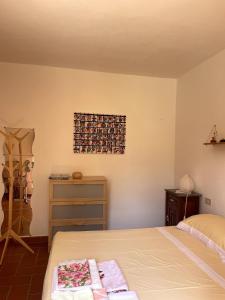 a bedroom with a bed and a dresser and a picture on the wall at Casa Lago di Brulli in Casole dʼElsa