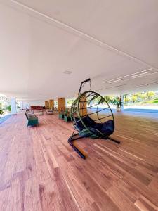 a large room with a machine on a wooden floor at Pontal do Lago Flat Residence, aproveite dias incríveis em família às margens do lago Corumbá in Caldas Novas