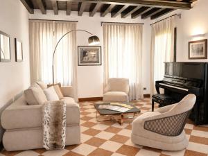 a living room with a couch and a piano at Hotel Scala - Buongiorno! Hotels in Treviso
