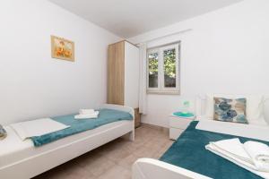 a bedroom with two beds and a window at Apartments with parking space Zavala, Hvar - 8710 in Jelsa