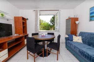 a living room with a table and a couch at Apartments with parking space Zavala, Hvar - 8710 in Jelsa