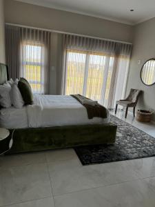 a bedroom with a large bed and a chair at Eye with a view in Eikenhof +38 photos