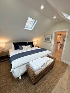 a bedroom with a large bed and a skylight at Ocean light | Deck + Patio • Central P-Town in Provincetown