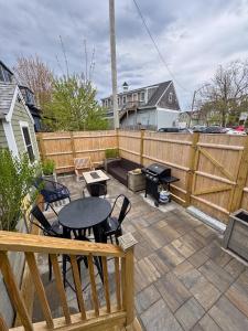 a patio with a table and chairs and a fence at Ocean light | Deck + Patio • Central P-Town in Provincetown