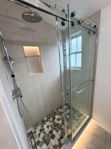 a shower with a glass door in a bathroom at Ocean light | Deck + Patio • Central P-Town in Provincetown
