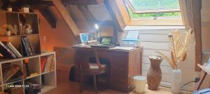a room with a desk with a laptop and a vase at La cazelle, dependance du 18 siecle, jacuzzi in Carsac-Aillac