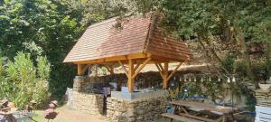 a wooden gazebo with a bench and a table at La cazelle, dependance du 18 siecle, jacuzzi in Carsac-Aillac +7 photos