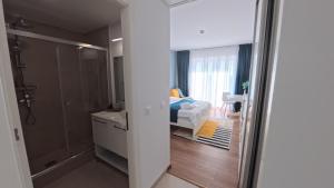 a bathroom with a shower and a bedroom with a bed at Cozy Studio Olimp in Olimp +11 photos