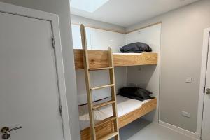 a room with bunk beds with a ladder in it at Hopetoun Bothy in Leadhills