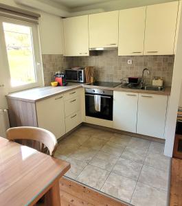 a kitchen with white cabinets and a stove top oven at Chalet Julian in Žaga +24 photos