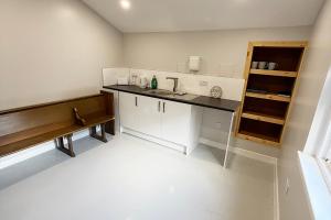 a kitchen with a sink and a bench in a room at Hopetoun Bothy in Leadhills