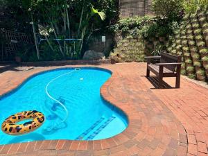 a swimming pool with a cookie in the middle with a bench at Victorian Beach Cottages in Amanzimtoti