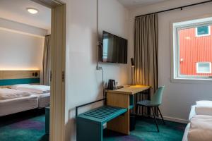 a hotel room with a desk and a bed at Hotel Aurora in Nuuk