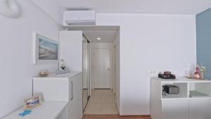 a white room with a hallway with white cabinets at Cozy Studio Olimp in Olimp