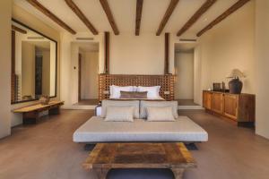 a bedroom with a large bed and a table at Klay Hotel Faralya Adults Only in Faralya