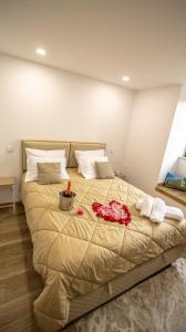 a large bed with red flowers on it in a room at A Casa do Penedo - Arcos de Valdevez in Arcos de Valdevez