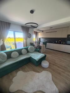 a living room with a green couch and a kitchen at L&D Apartments in Urseni