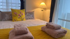 ein Schlafzimmer mit einem Bett, auf dem Handtücher liegen in der Unterkunft SunSea Okinawa Stunning Ocean View 2BR Sleeps 6 20 min from Airport 3 min to Shopping Mall in Urazoe