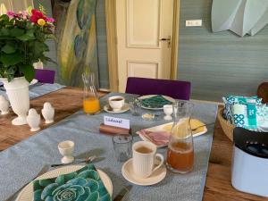 a table with plates and cups of coffee on it at B&B Pastorie Jelsum in Jelsum
