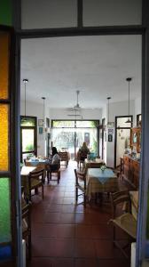 a room with tables and chairs and people sitting at tables at Posada del Angel in Colonia del Sacramento