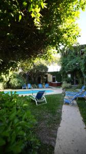 a group of chairs sitting around a swimming pool at Posada del Angel in Colonia del Sacramento
